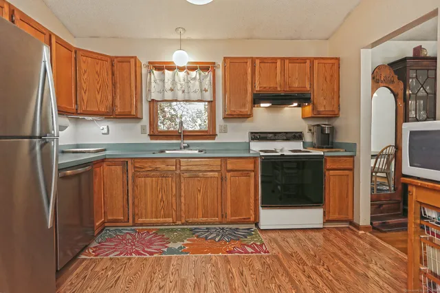 a kitchen with stainless steel appliances granite countertop a stove a sink and a refrigerator