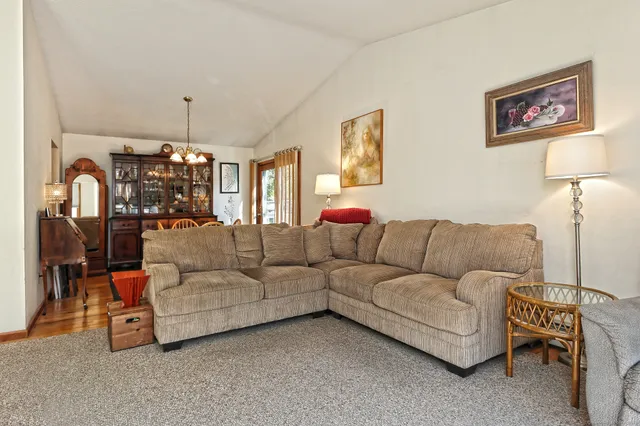 a living room with furniture a chandelier and a window