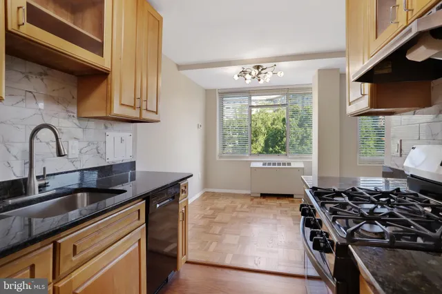 a kitchen with a sink stove top oven and cabinets
