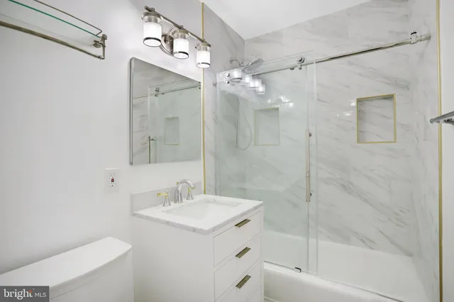 a bathroom with a bathtub shower sink vanity and a toilet