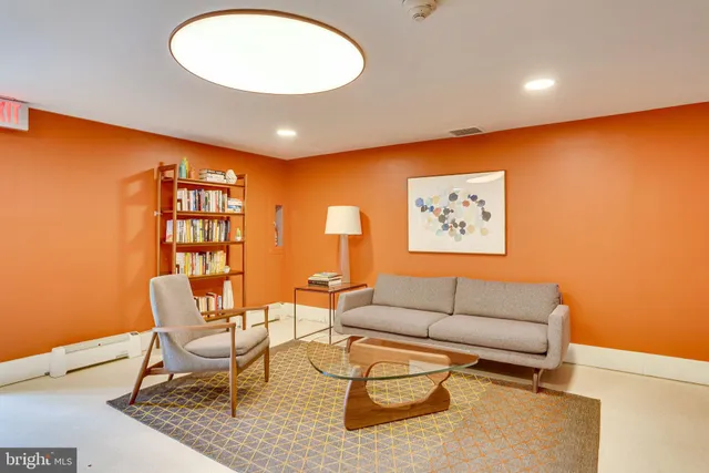 a living room with furniture a rug and a wall painting