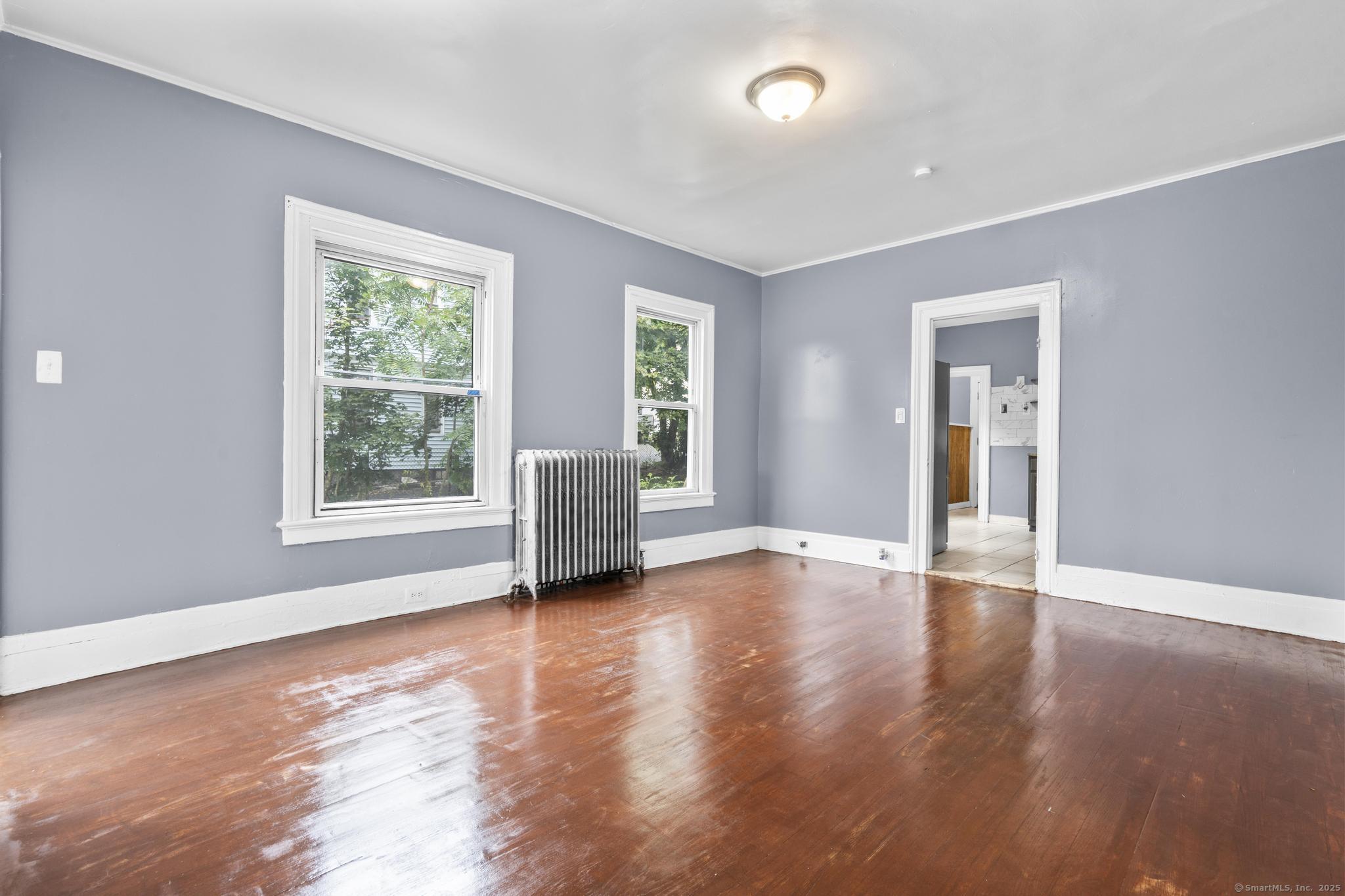 1105 North Main Street, Unit 1 Waterbury, CT 06704 - Photo 13 of 37 a view of an empty room with window and wooden floor