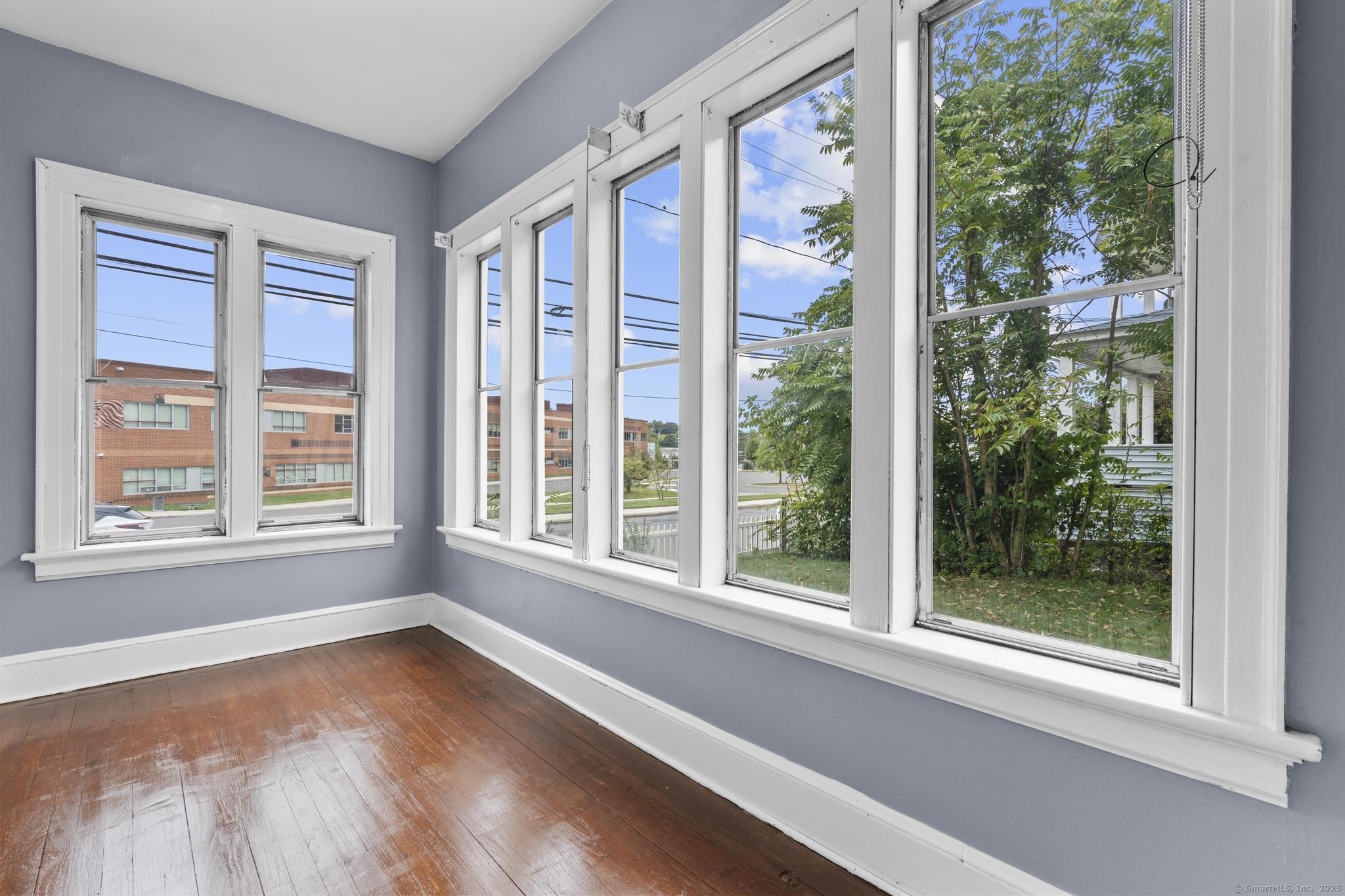 1105 North Main Street, Unit 1 Waterbury, CT 06704 - Photo 17 of 37 a view of an empty room with wooden floor and a window