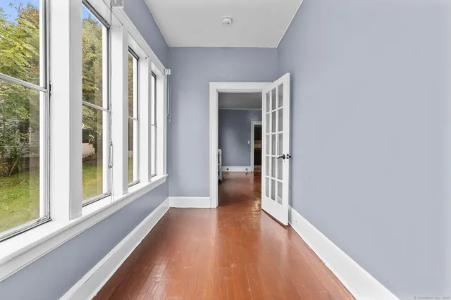 a view of a hallway with wooden floor and windows