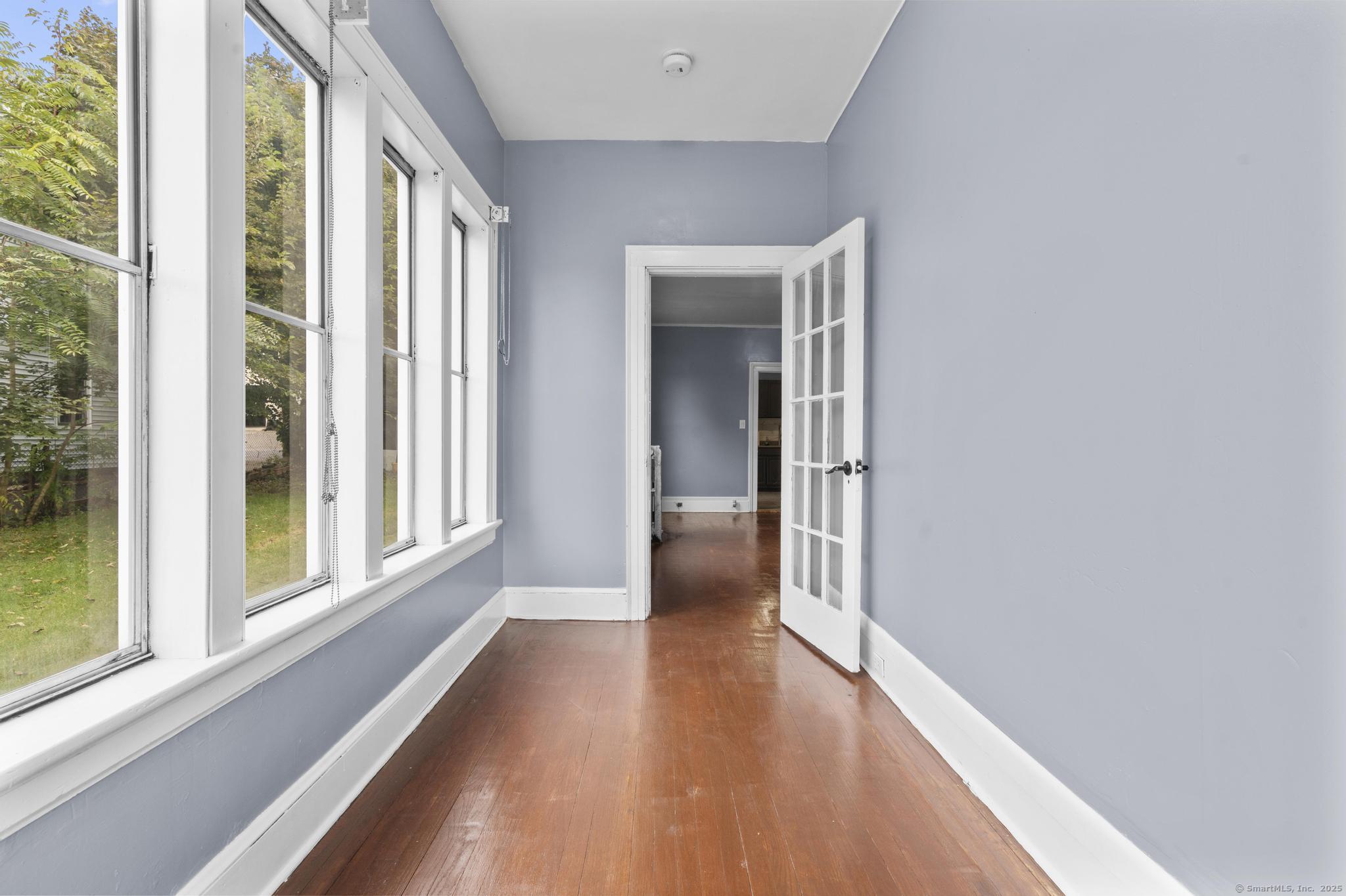 1105 North Main Street, Unit 1 Waterbury, CT 06704 - Photo 18 of 37 a view of a hallway with wooden floor and windows