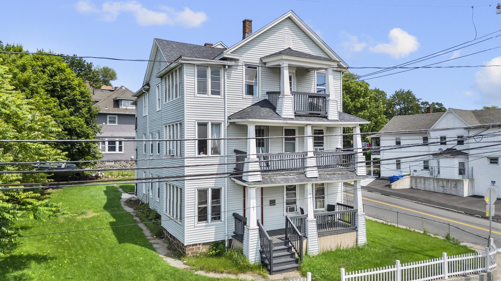 1105 North Main Street, Unit 1 Waterbury, CT 06704 - Photo 2 of 37 front view of a house with a yard