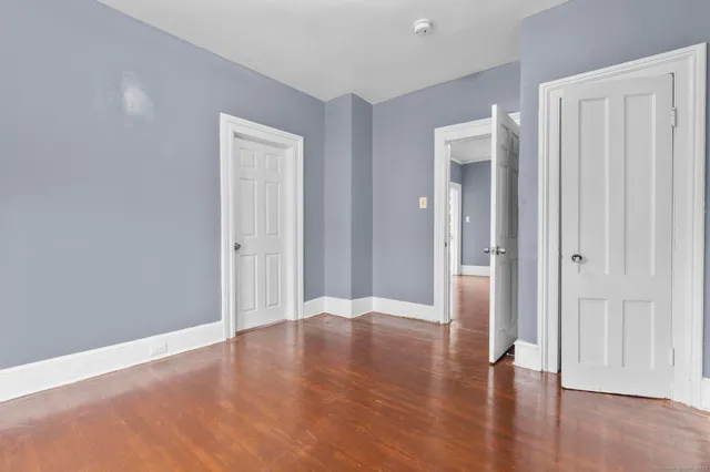 a view of an empty room with wooden floor