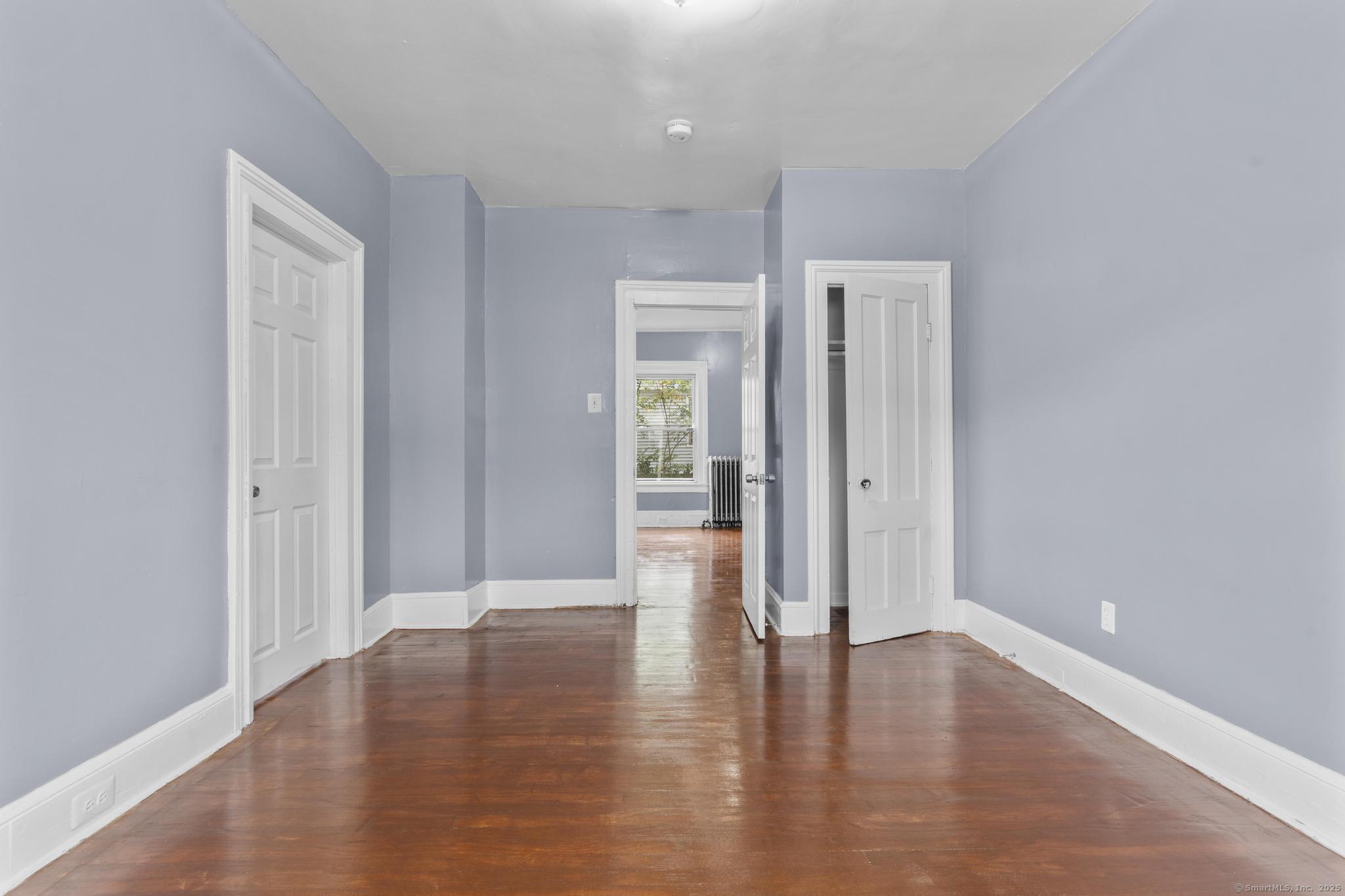 1105 North Main Street, Unit 1 Waterbury, CT 06704 - Photo 24 of 37 a view of an empty room with wooden floor and a window