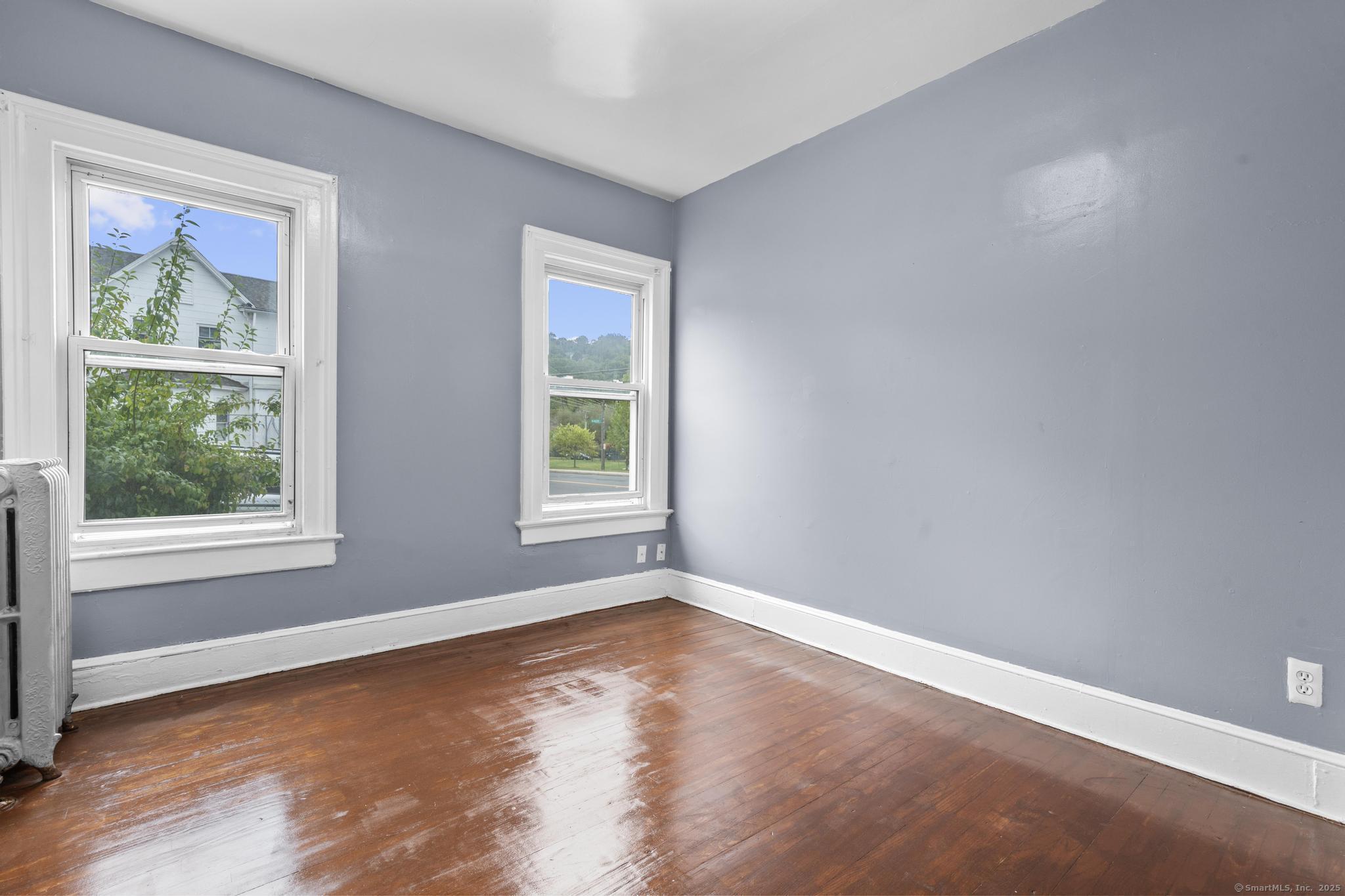 1105 North Main Street, Unit 1 Waterbury, CT 06704 - Photo 25 of 37 a view of an empty room with wooden floor and a window