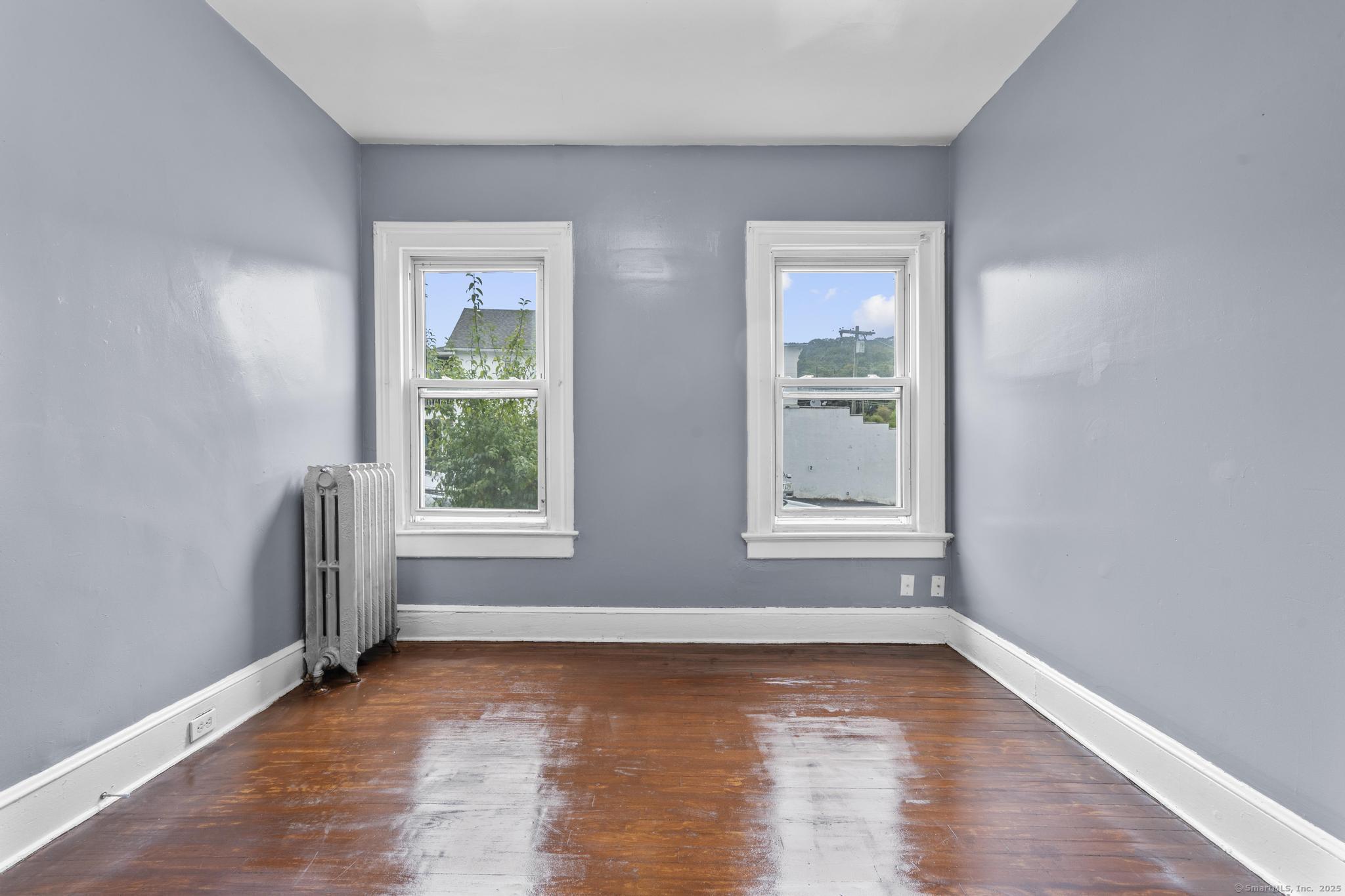 1105 North Main Street, Unit 1 Waterbury, CT 06704 - Photo 27 of 37 a view of an empty room with wooden floor and a window