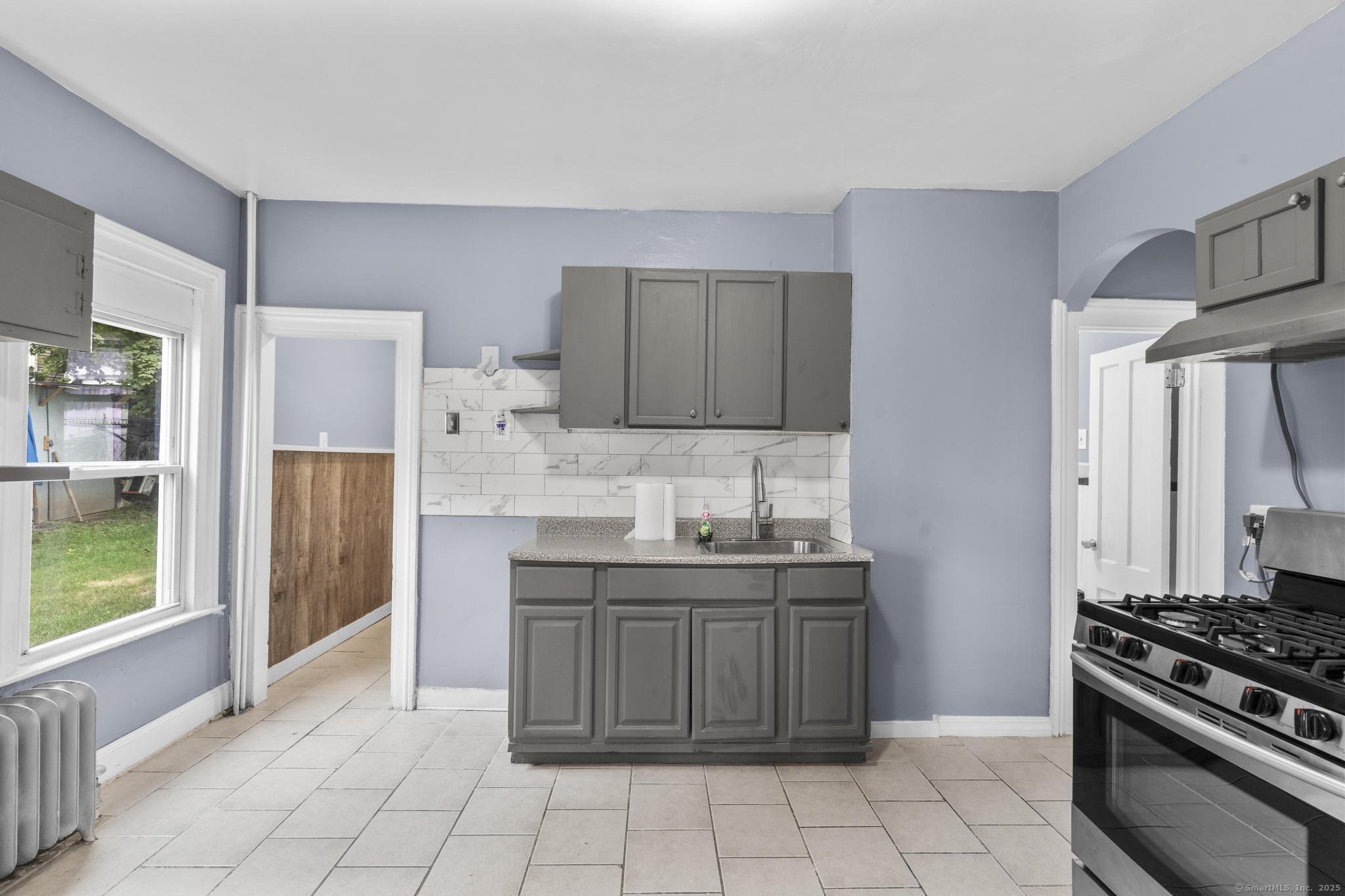1105 North Main Street, Unit 1 Waterbury, CT 06704 - Photo 28 of 37 a kitchen with stainless steel appliances granite countertop a stove a sink and a refrigerator