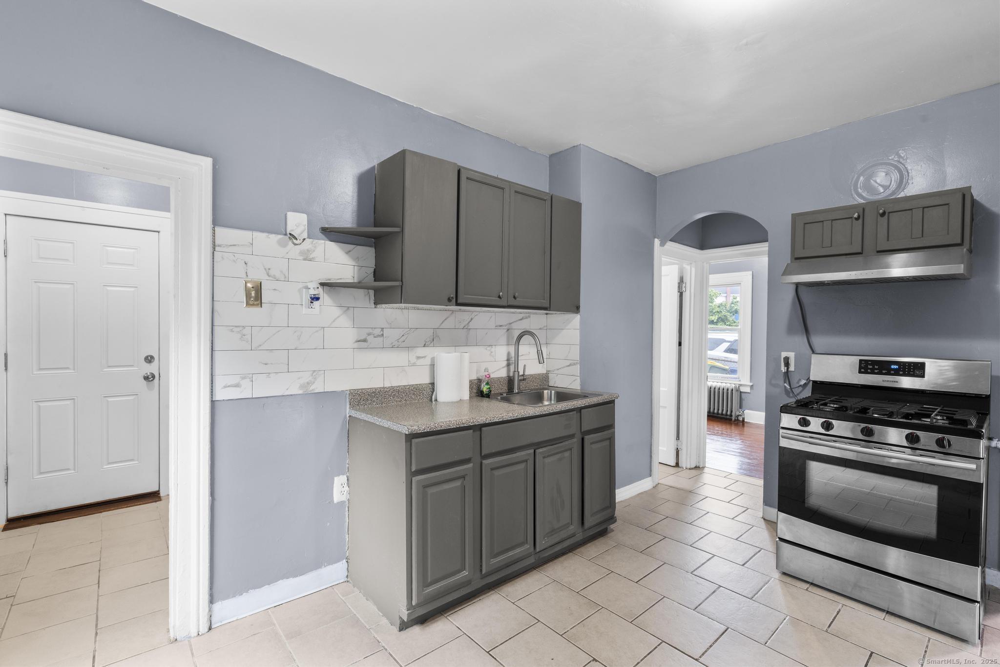 1105 North Main Street, Unit 1 Waterbury, CT 06704 - Photo 29 of 37 a kitchen with stainless steel appliances a stove sink and cabinets