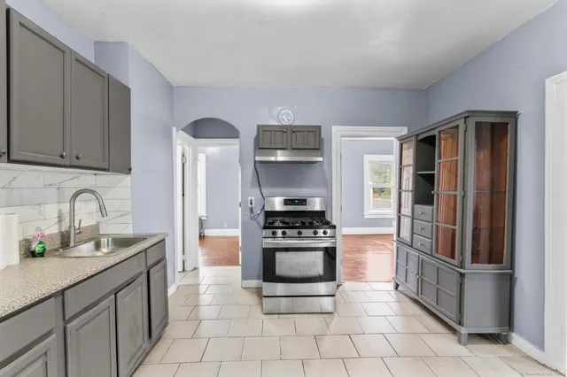 a kitchen with stainless steel appliances granite countertop a stove a refrigerator and a sink