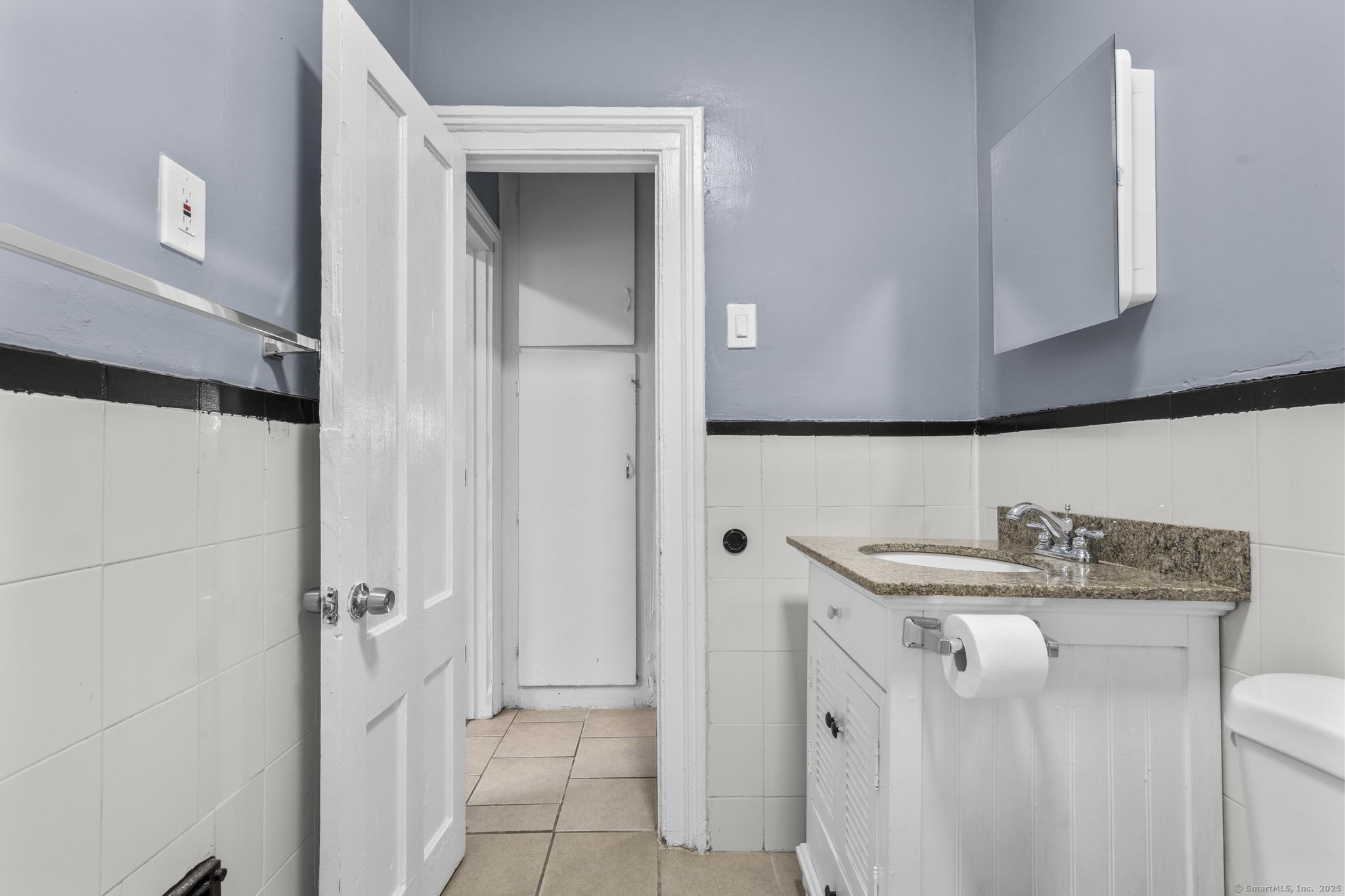 1105 North Main Street, Unit 1 Waterbury, CT 06704 - Photo 33 of 37 a bathroom with a sink and a mirror