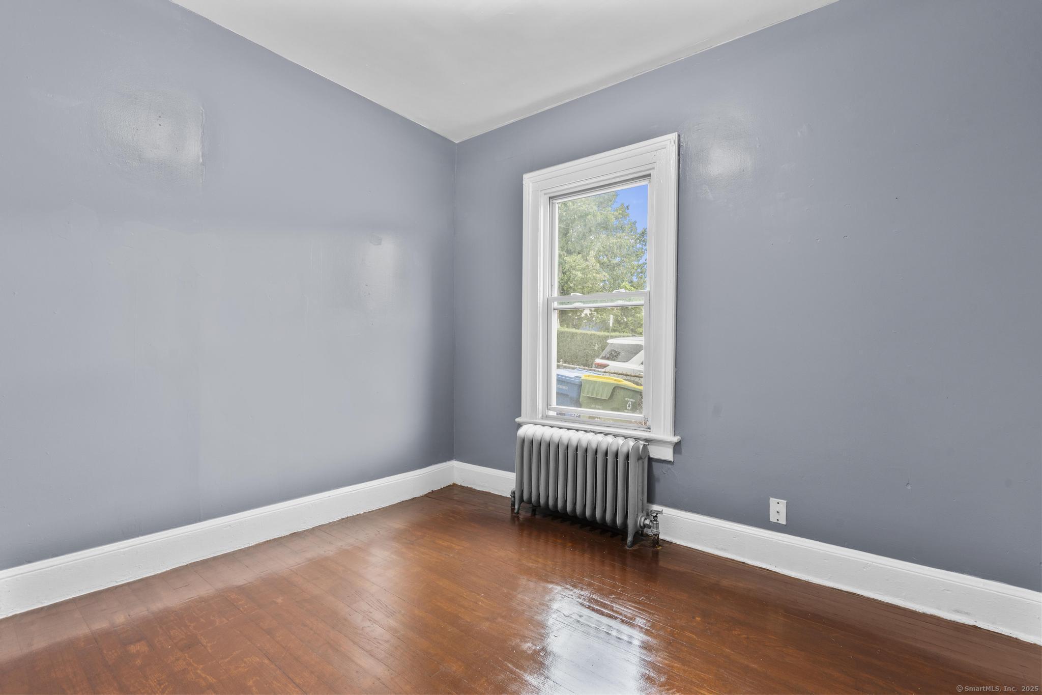 1105 North Main Street, Unit 1 Waterbury, CT 06704 - Photo 34 of 37 an empty room with wooden floor and windows