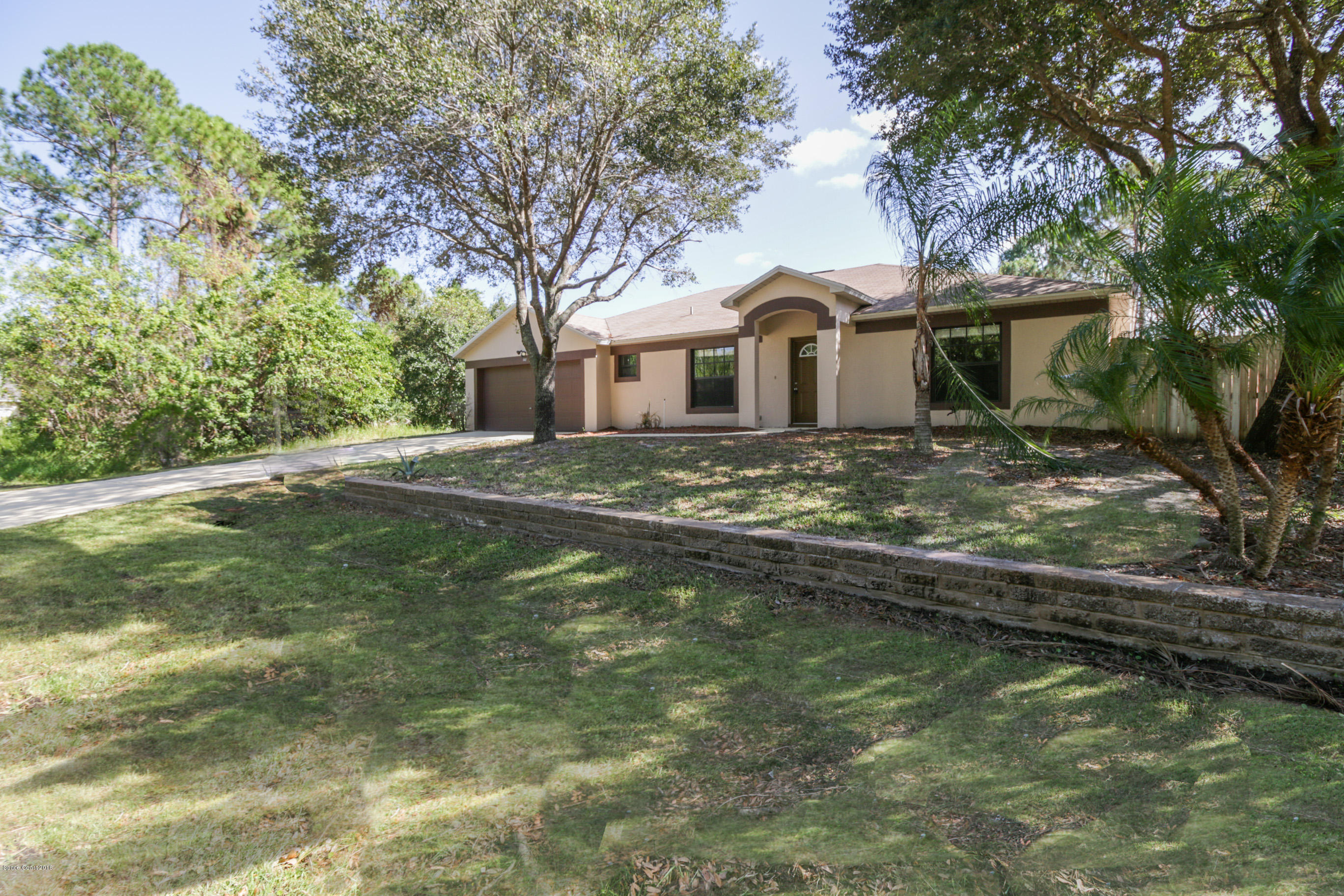 441 Wildmer Road Southwest Palm Bay, FL 32908 - Photo 2 of 67 a front view of a house with a garden