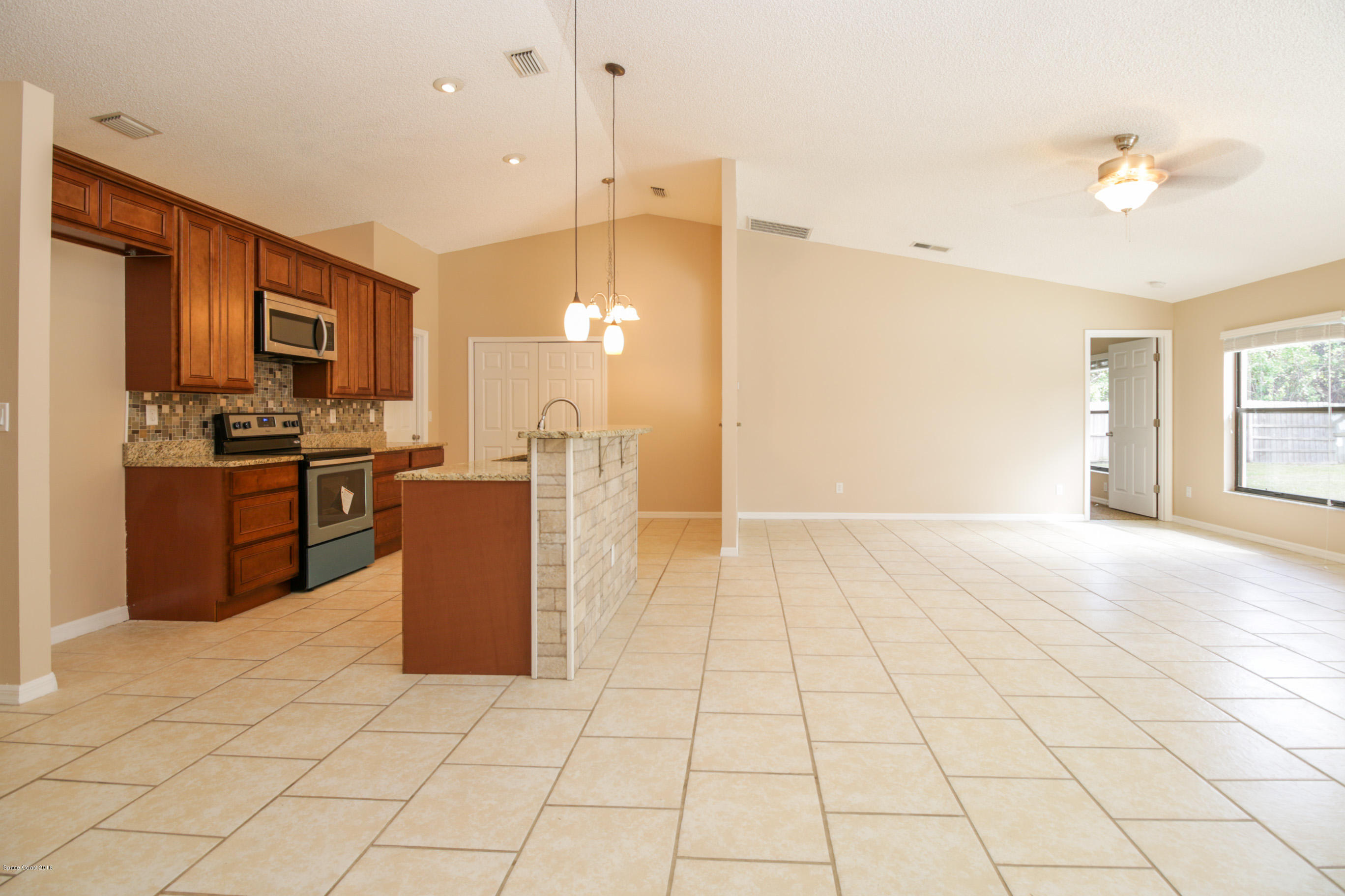 441 Wildmer Road Southwest Palm Bay, FL 32908 - Photo 14 of 67 a kitchen with stainless steel appliances kitchen island granite countertop a refrigerator a stove top oven and a sink