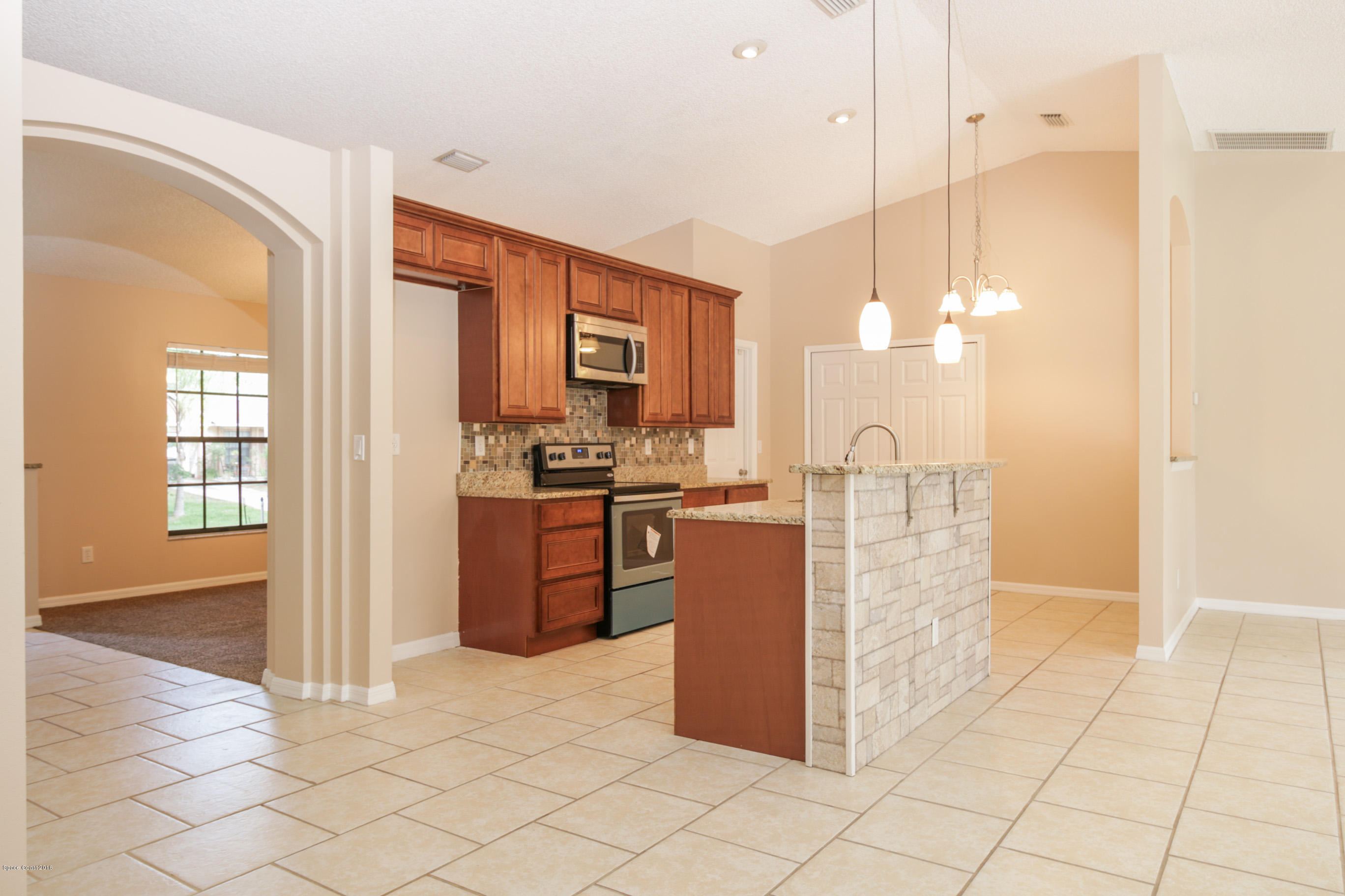 441 Wildmer Road Southwest Palm Bay, FL 32908 - Photo 16 of 67 a kitchen with stainless steel appliances kitchen island granite countertop a refrigerator and a sink