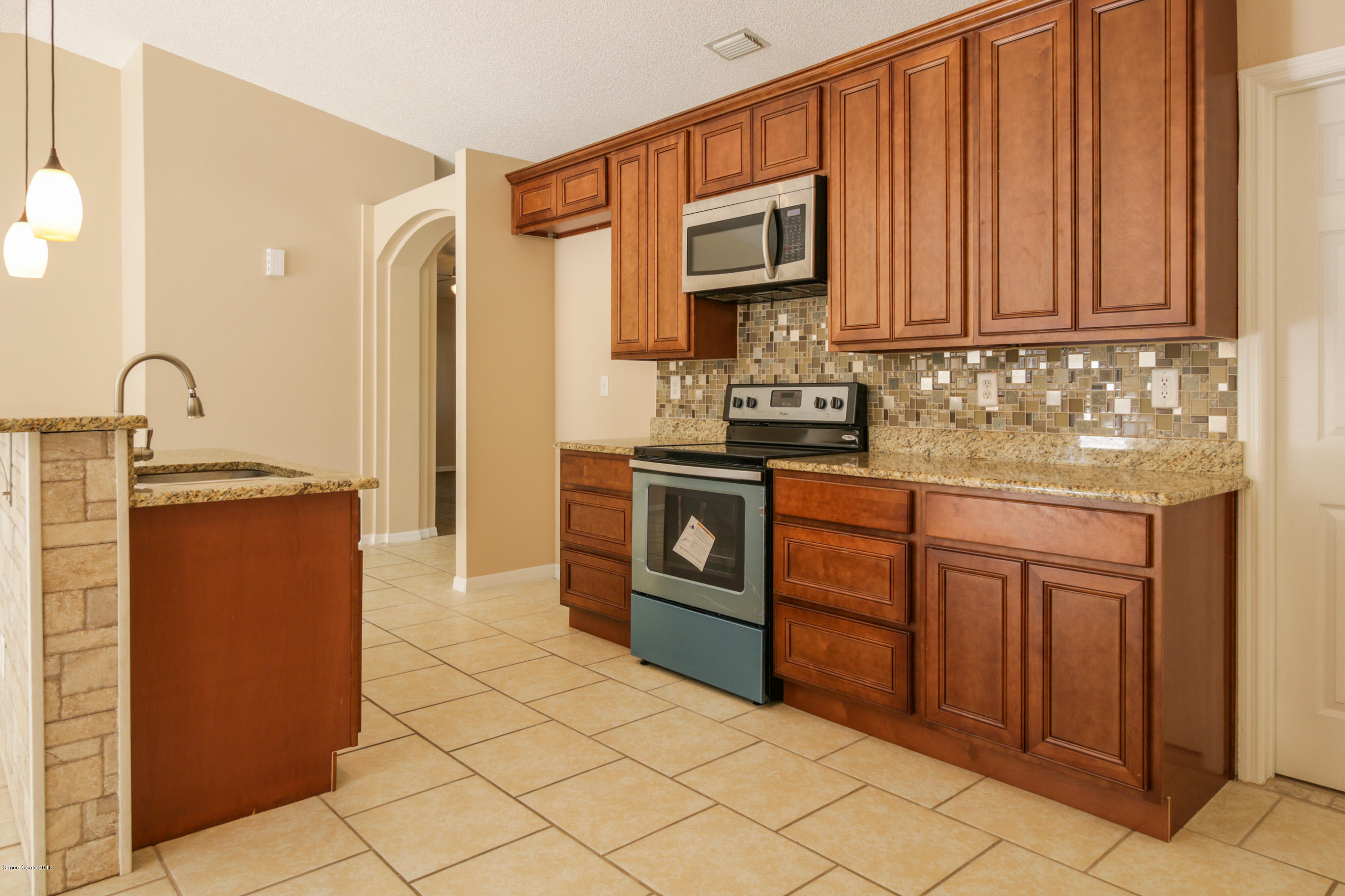 441 Wildmer Road Southwest Palm Bay, FL 32908 - Photo 20 of 67 a kitchen with stainless steel appliances granite countertop a sink stove and refrigerator
