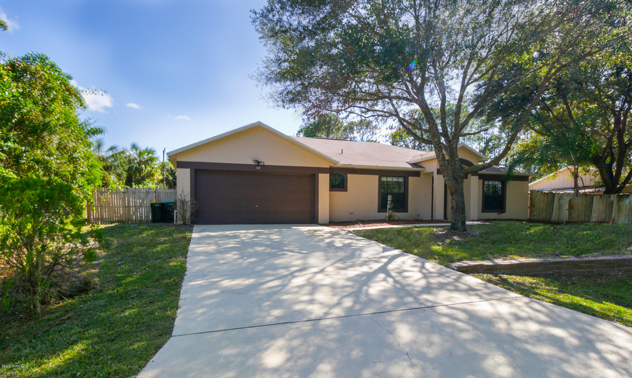 441 Wildmer Road Southwest Palm Bay, FL 32908 - Photo 3 of 67 a front view of a house with a garden and trees