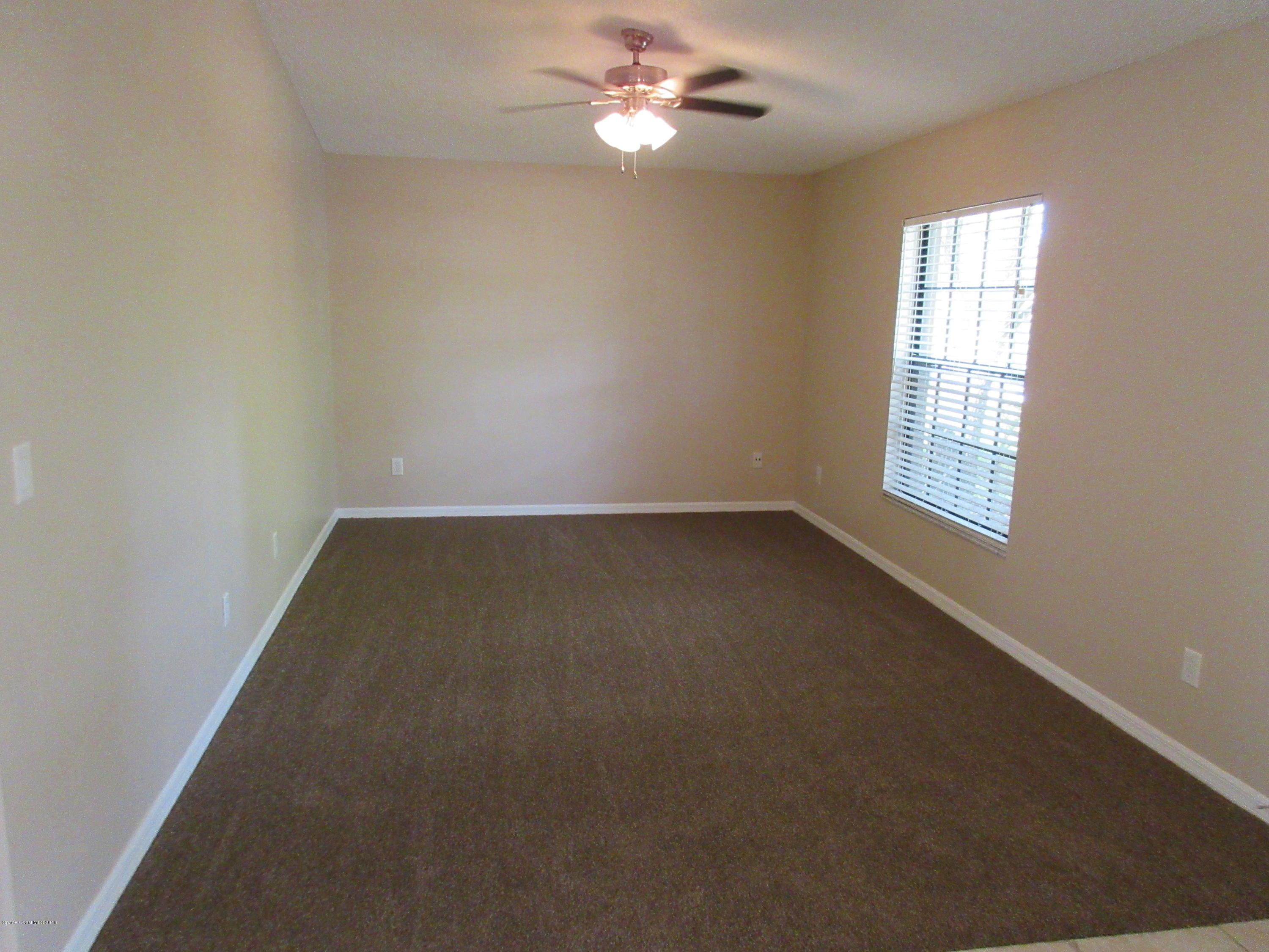 441 Wildmer Road Southwest Palm Bay, FL 32908 - Photo 21 of 67 an empty room with windows and fan