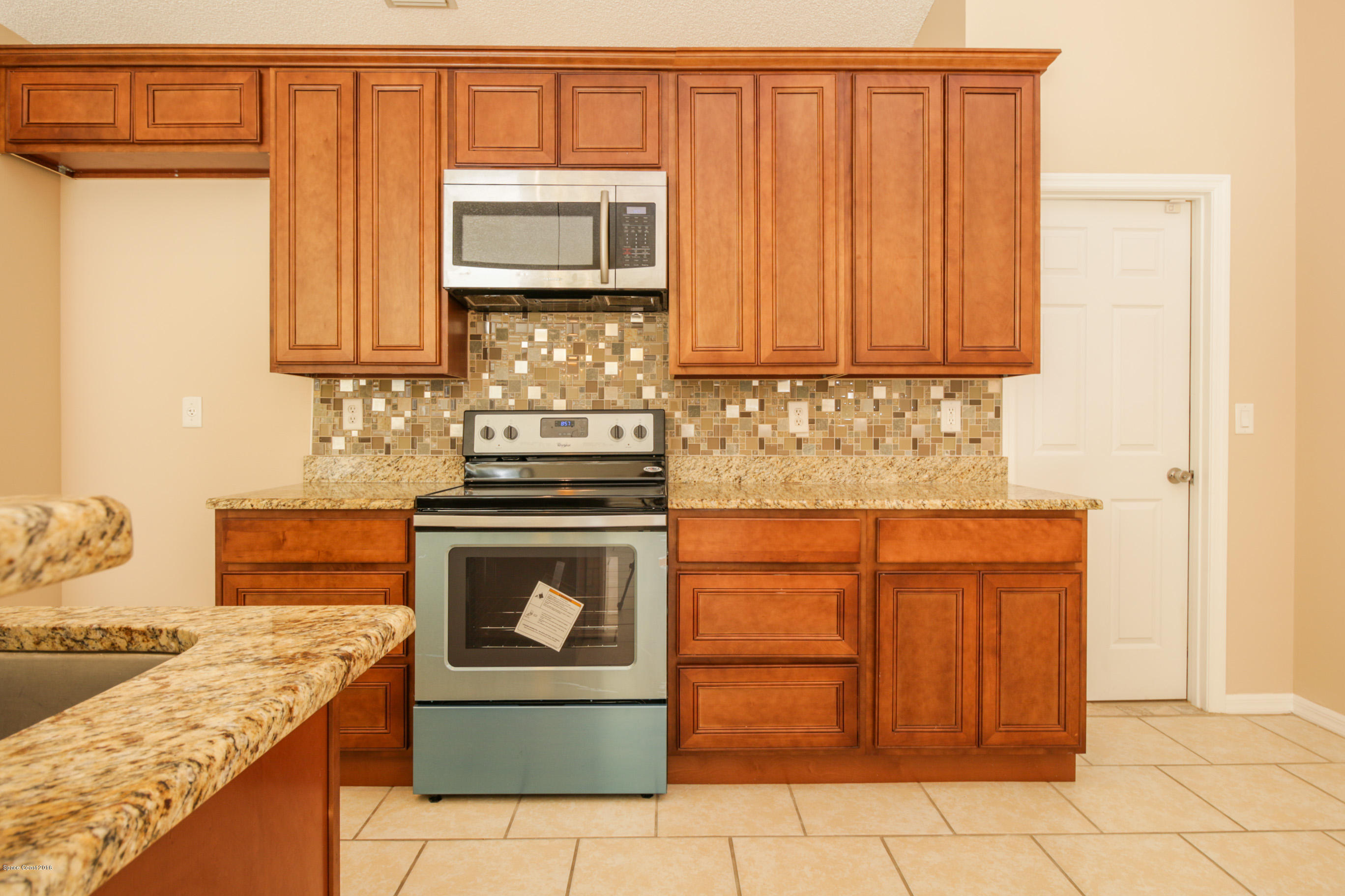 441 Wildmer Road Southwest Palm Bay, FL 32908 - Photo 24 of 67 a kitchen with stainless steel appliances granite countertop a stove a washer and dryer