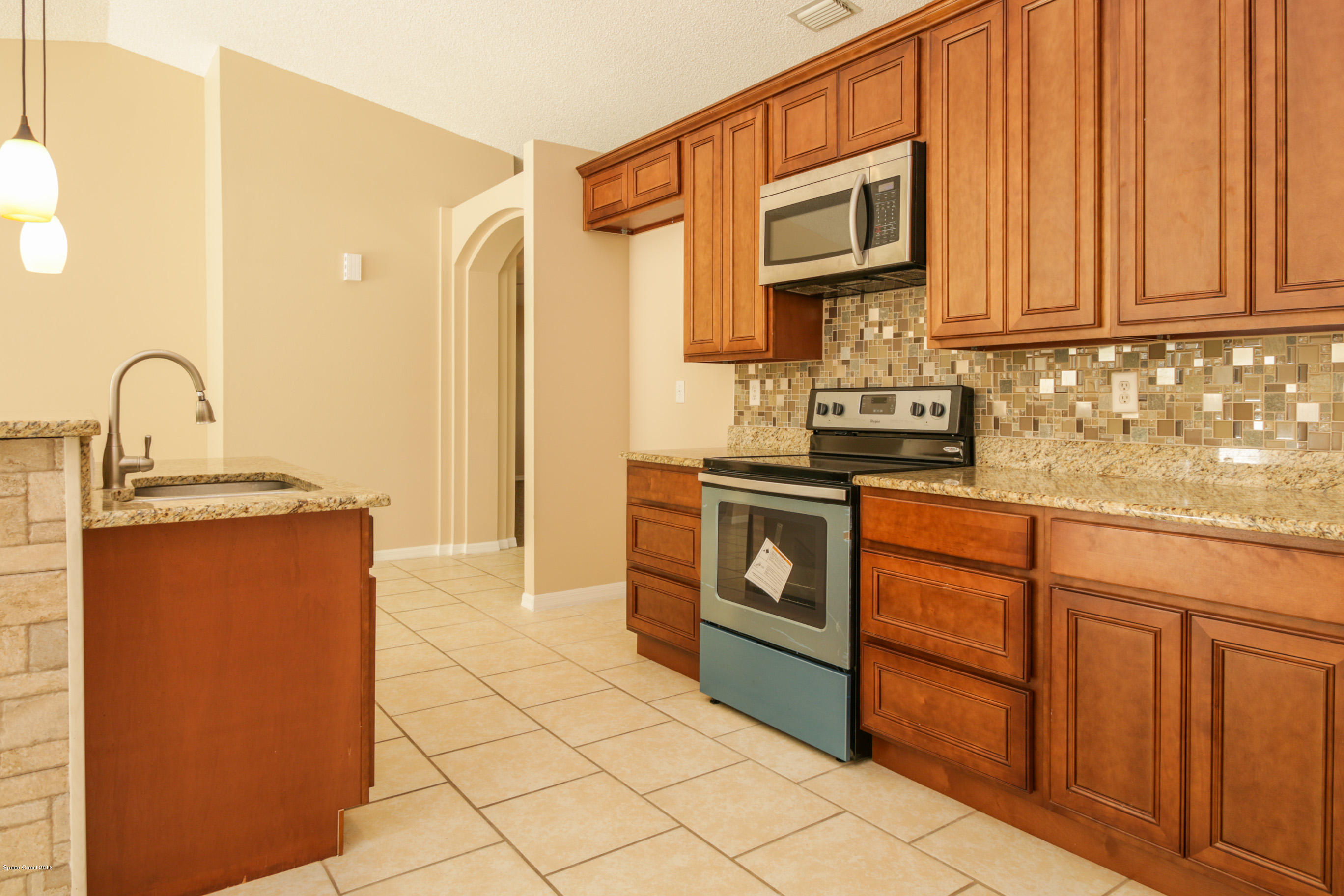 441 Wildmer Road Southwest Palm Bay, FL 32908 - Photo 26 of 67 a kitchen with stainless steel appliances granite countertop a stove a sink and a microwave