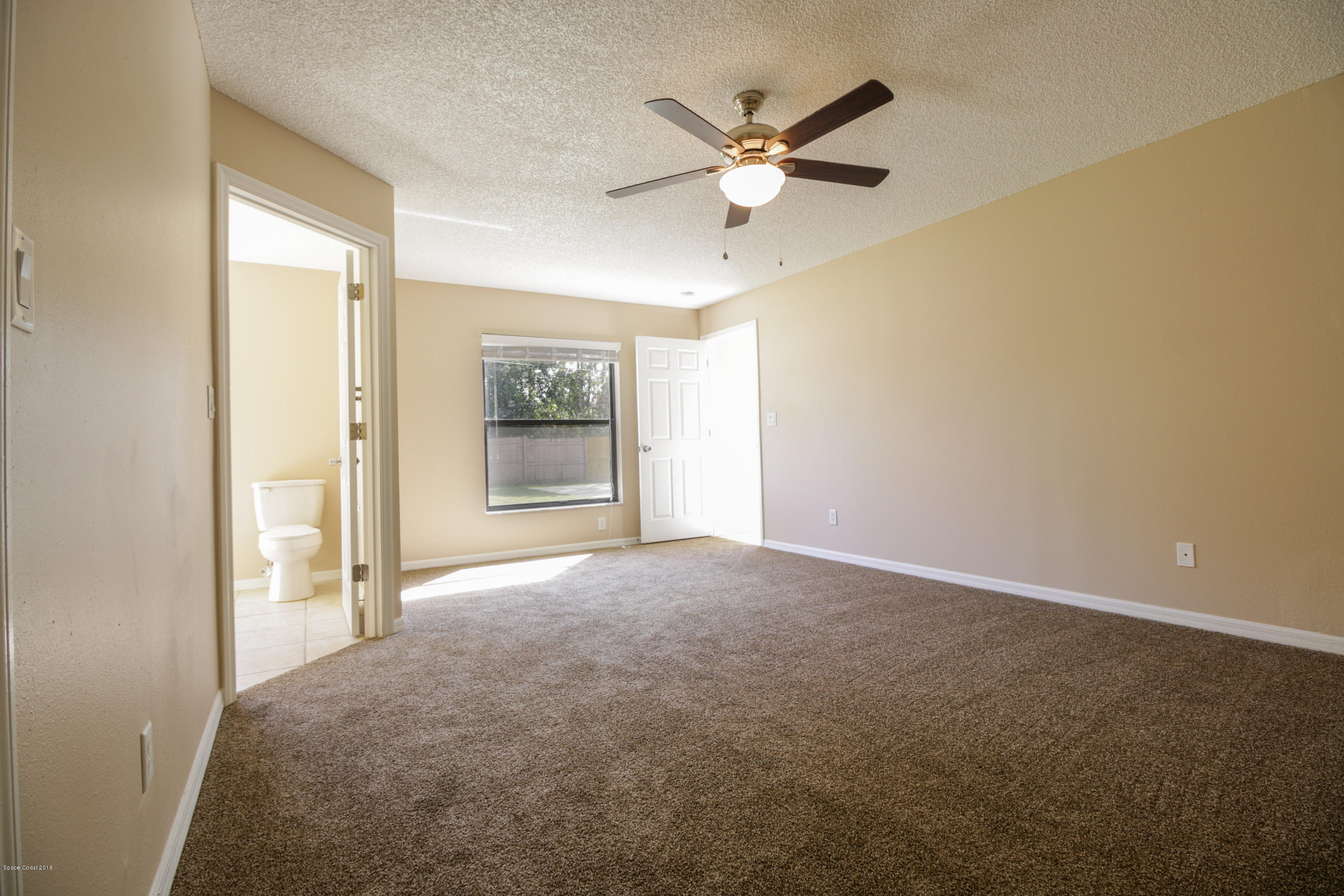 441 Wildmer Road Southwest Palm Bay, FL 32908 - Photo 31 of 67 an empty room with a ceiling fan and a window
