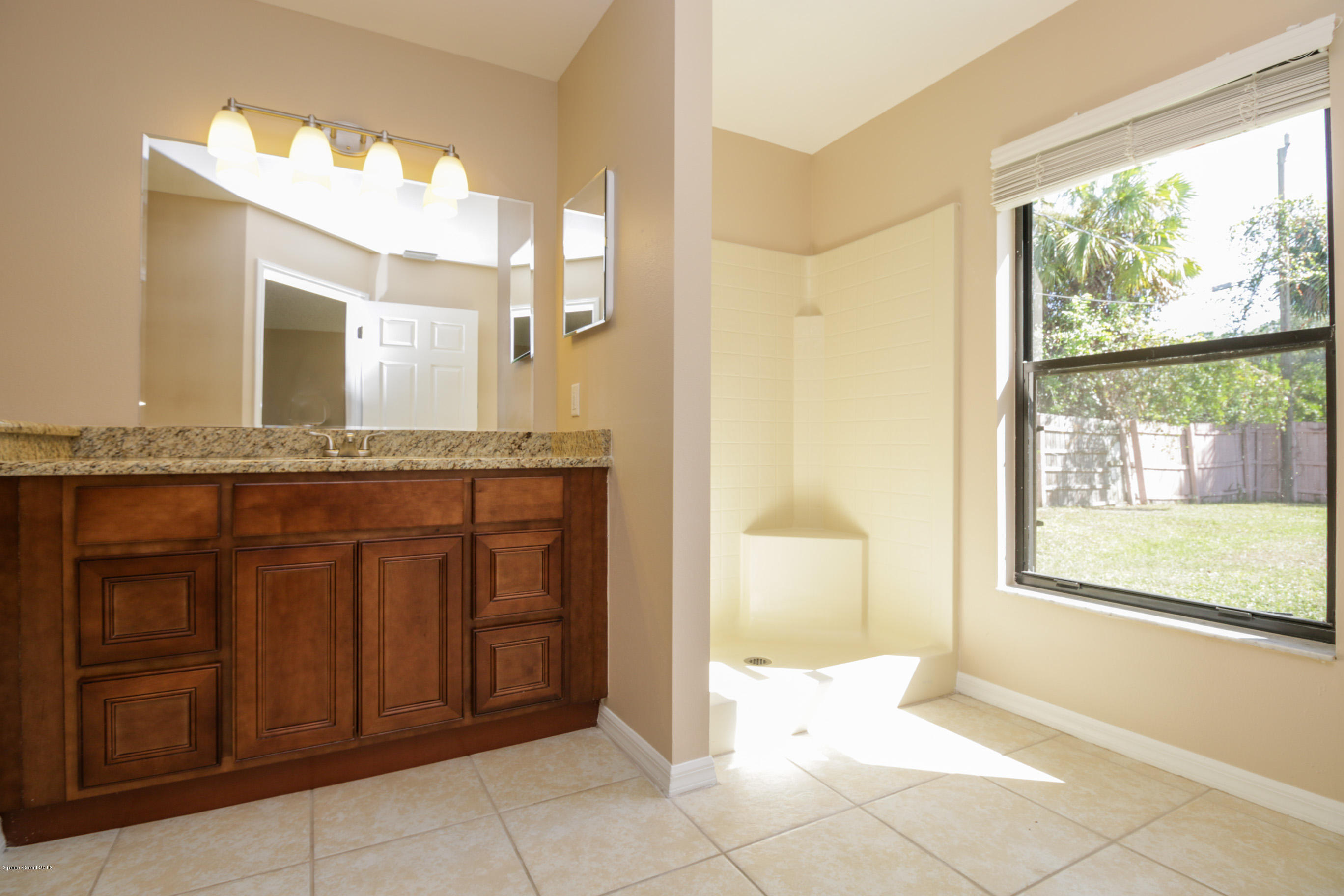 441 Wildmer Road Southwest Palm Bay, FL 32908 - Photo 39 of 67 a bathroom with a granite countertop sink and a mirror