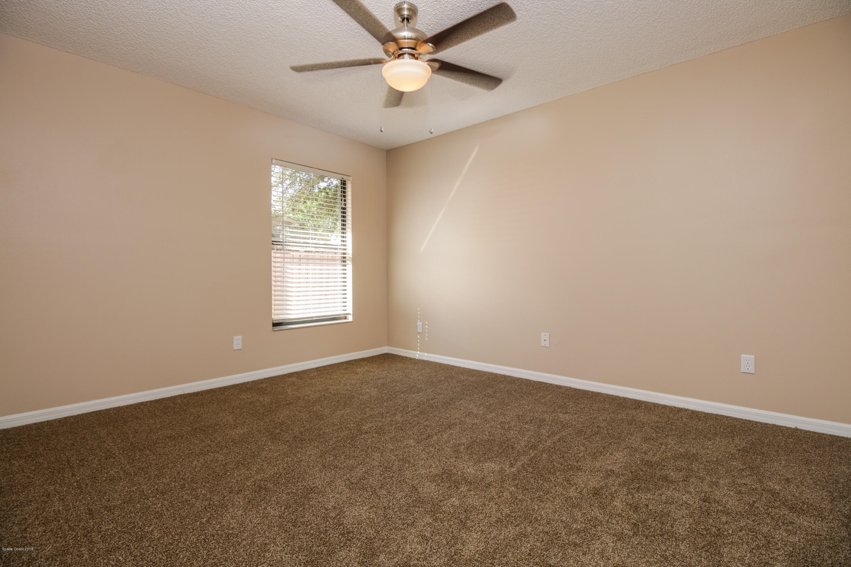 441 Wildmer Road Southwest Palm Bay, FL 32908 - Photo 47 of 67 an empty room with a window and a fan