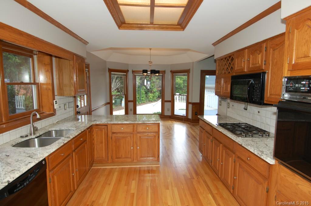 425 St Michaels Way Fort Mill, SC 29708 - Photo 5 of 21 a large kitchen with granite countertop a stove top oven a sink a counter space and cabinets