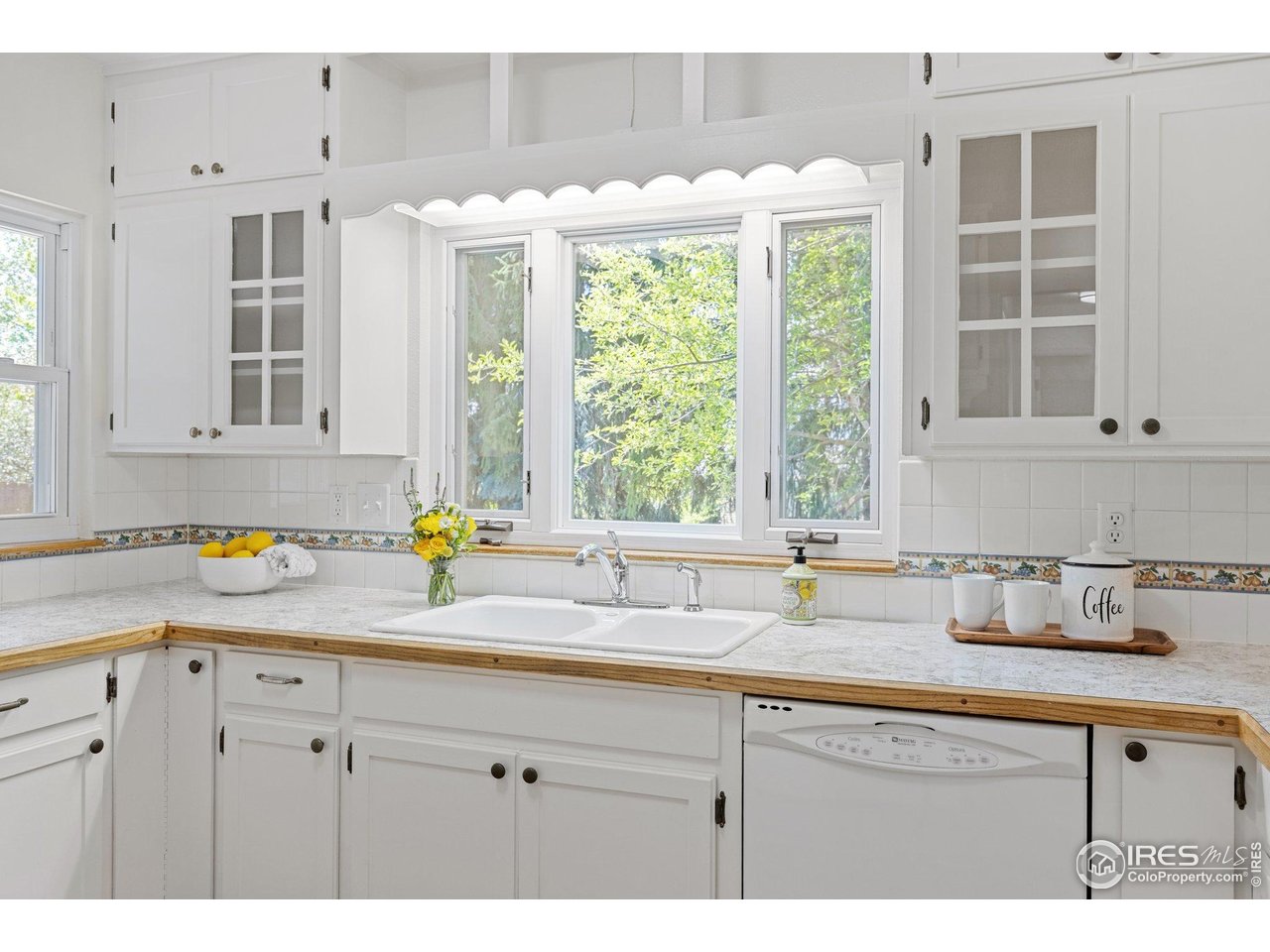 27 Cornell Drive Longmont, CO 80503 - Photo 13 of 33 a kitchen with granite countertop a sink white cabinets and a window