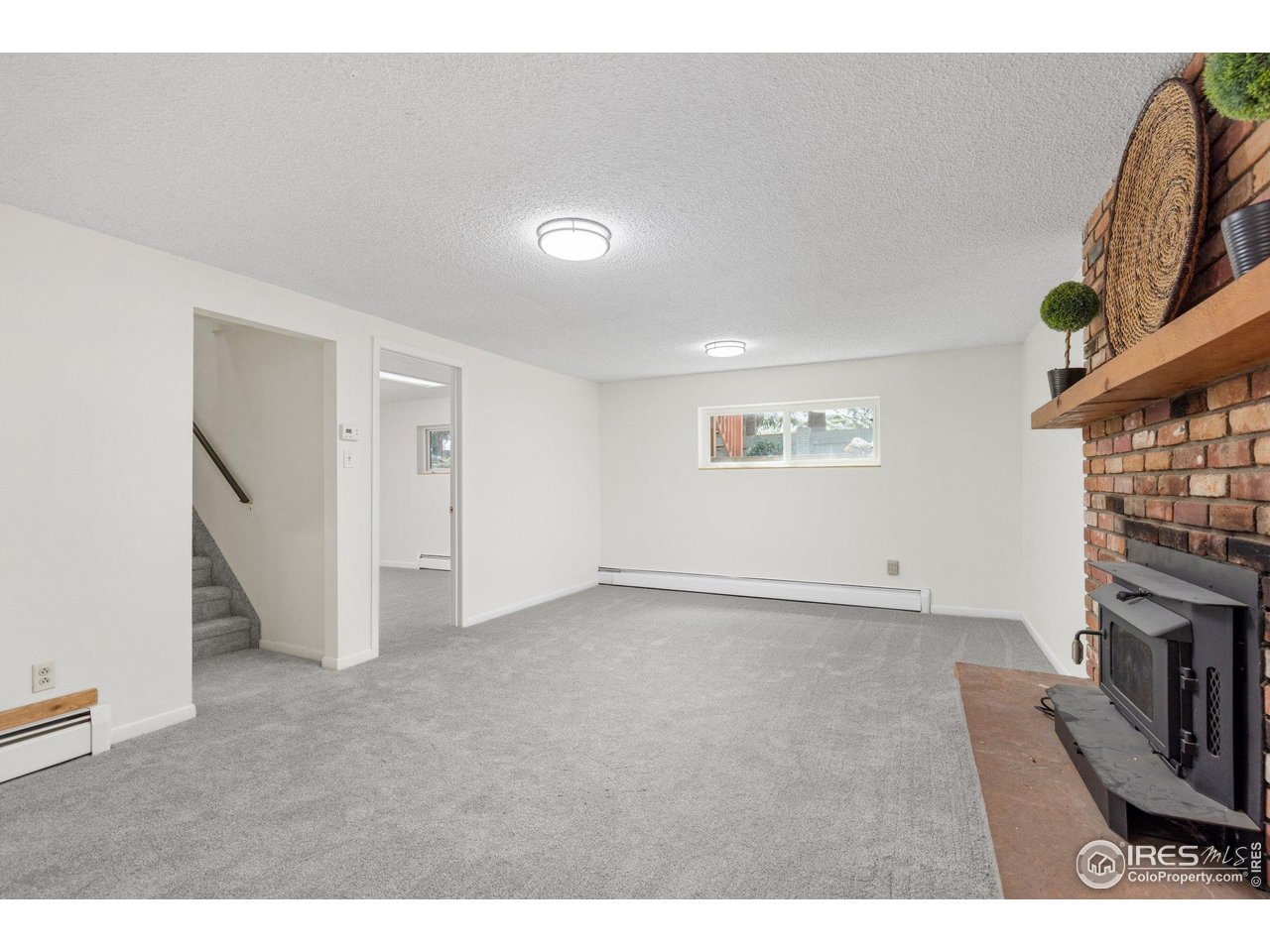 27 Cornell Drive Longmont, CO 80503 - Photo 23 of 33 a view of an empty room with a fireplace and a window