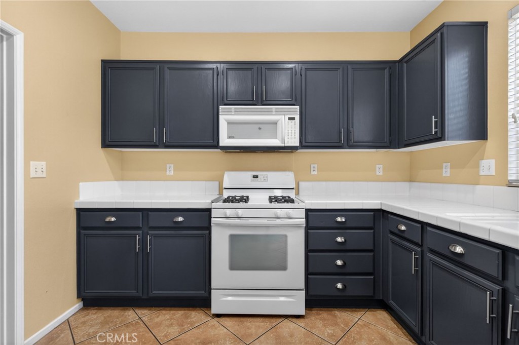 3958 Barbury Palms Way Perris, CA 92571 - Photo 3 of 35 a kitchen with a cabinets and white stove