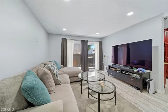 a living room with furniture a flat screen tv and a window