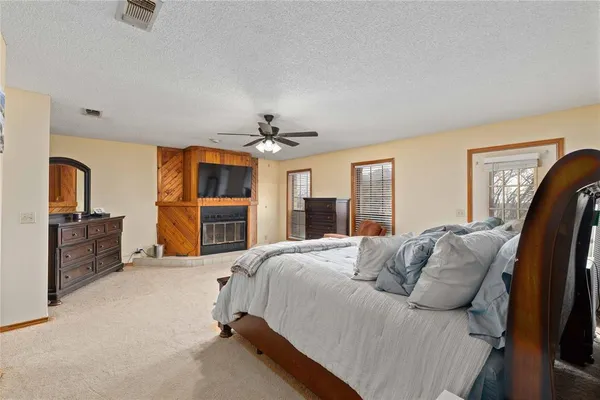 a spacious bedroom with a bed and ceiling fan