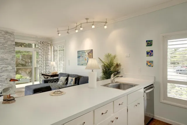a kitchen with a sink a counter top space and living room
