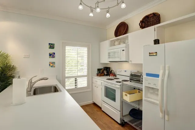 a kitchen that has a sink a stove and a refrigerator
