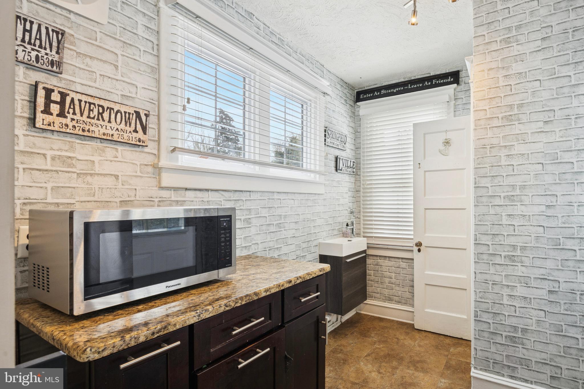 120 West Springfield Road Springfield, PA 19064 - Photo 13 of 35 a kitchen with granite countertop white cabinets and black appliances