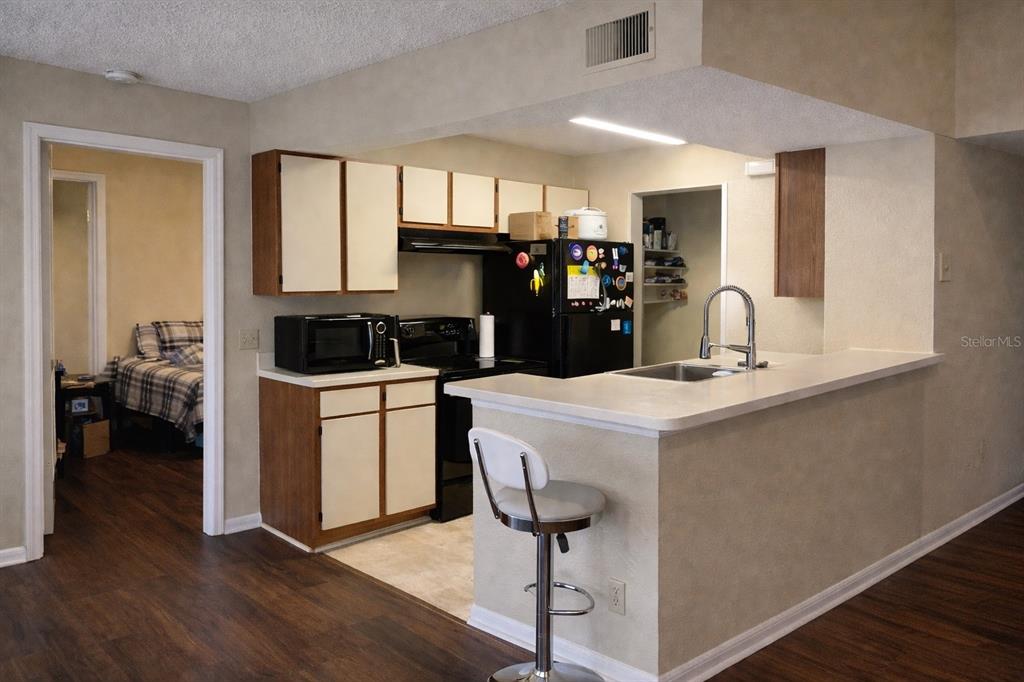 1049 South Hiawassee Road, Unit 3422 Orlando, FL 32835 - Photo 4 of 14 a kitchen with a stove a sink and a refrigerator