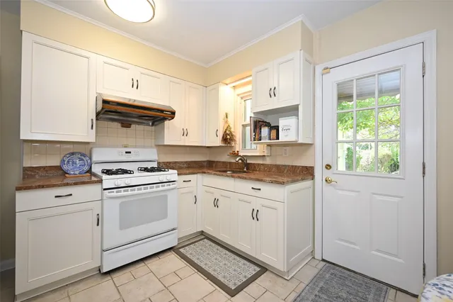 a kitchen with granite countertop white cabinets and white appliances