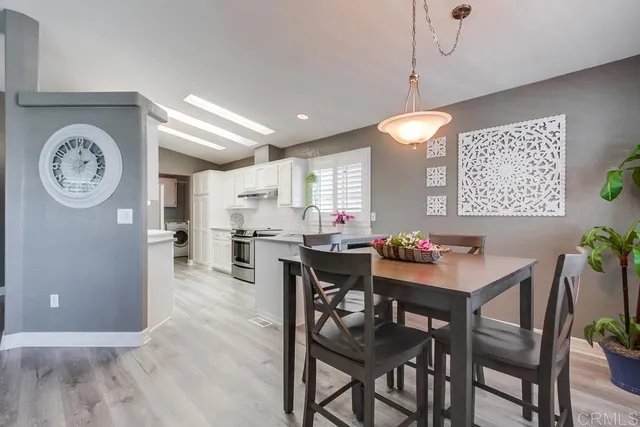 a view of a dining room and livingroom with furniture wooden floor and a clock