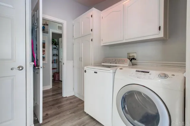 a view of a hallway with wooden floor and a painting on the wall