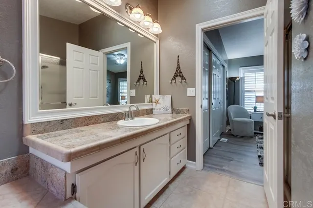 a bathroom with a granite countertop sink a toilet and a mirror