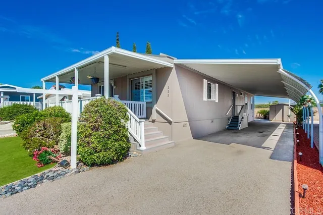 a view of a house with a yard and potted plants