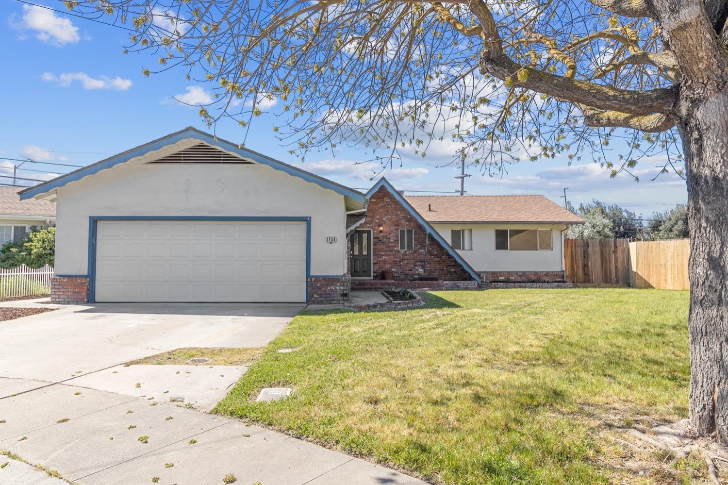 1854 Waring Way Modesto, CA 95350 - Photo 1 of 1 a front view of a house with a yard and garage