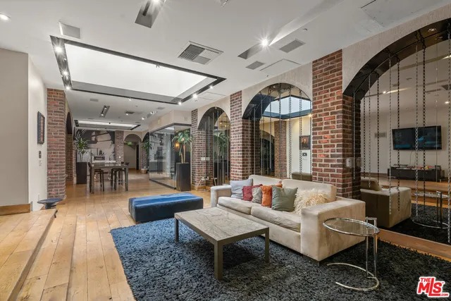 a living room with furniture a chandelier and a dining table