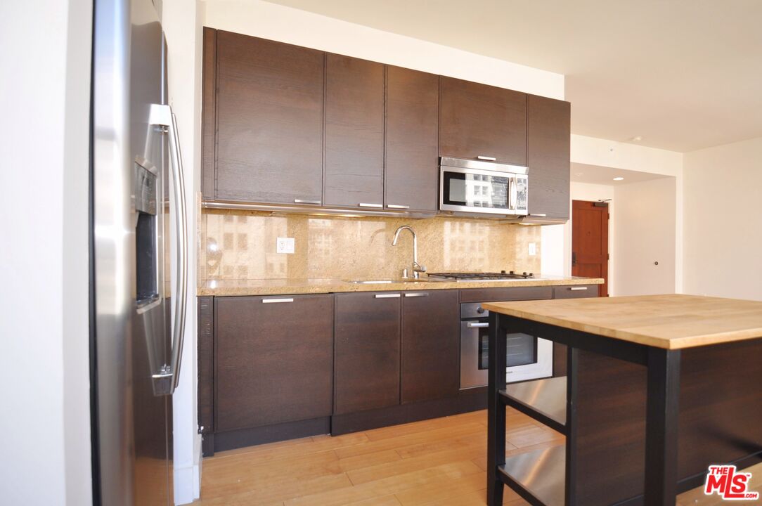 460 South Spring Street, Unit 701 Los Angeles, CA 90013 - Photo 3 of 32 a kitchen with a sink a window and cabinets