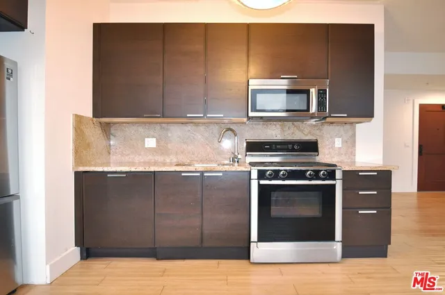 a kitchen with stainless steel appliances granite countertop a stove and a microwave