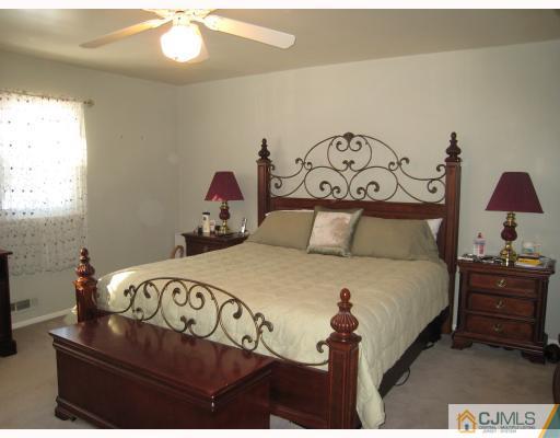 6 Sherwood Road Edison, NJ 08820 - Photo 7 of 10 a bedroom with a bed and a chandelier